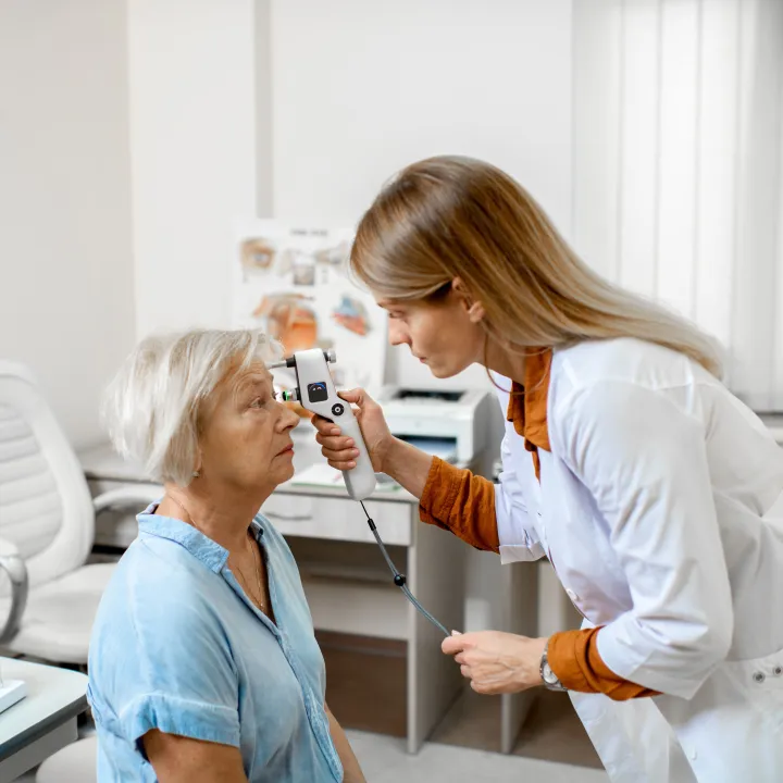 A doctor checks the eye pressure of a senior woman for diabetic eye disease