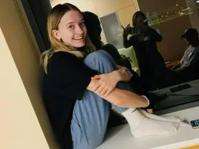 Photo of Ulyssia sitting with her legs folded to her chest