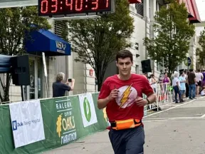 Photo of Robert crossing a marathon finish line