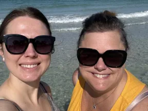 Close up photo of Leora and a friend on a beach
