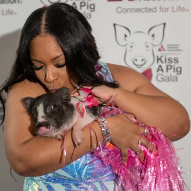 Woman kissing a pig for charity