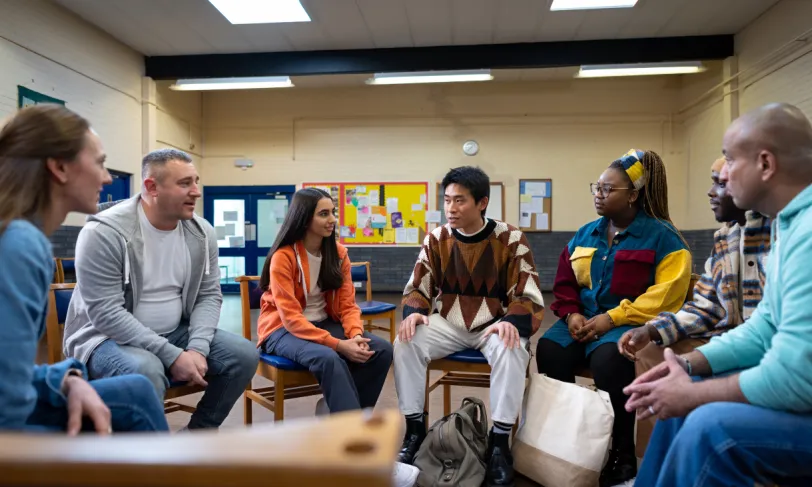 Mixed group of people sitting in a classroom having a discussion