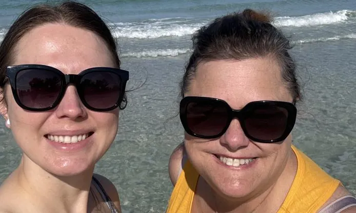 Close up photo of Leora and a friend on a beach