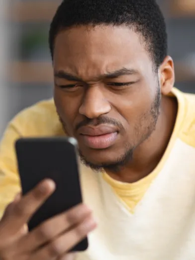 A man struggles to read his phone due to diabetes related eye complications